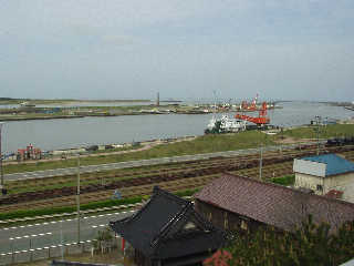 展望台から酒田港を望む。奥は最上川河口。手前に貨物線「酒田港線」が走る。